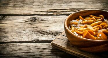 Marinated mushrooms in a bowl on the Board. photo