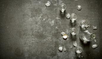 bottle of vodka with glasses and ice. photo