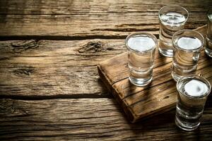 Glasses with vodka on the old Board. photo