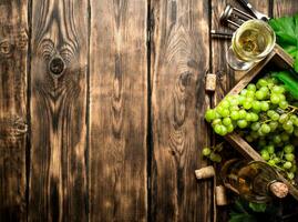 White wine with a box full of grapes. photo