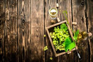 White wine with a box full of grapes. photo