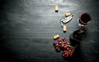 Bottle of red wine with a corkscrew. photo