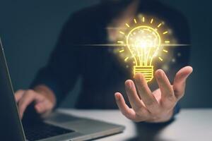 Idea lightbulb moment, man with lightbulbs floating above his hand, representing a moment of creative inspiration. photo