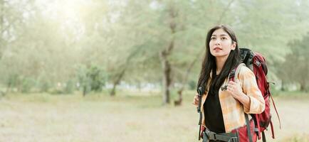 Asian woman hiking in the forest, feeling refreshed and energized. photo