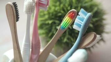 escovas de dentes coloridas em caneca branca contra a parede video