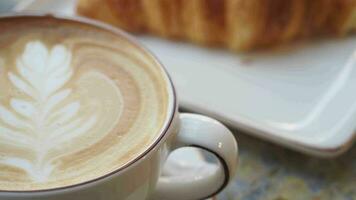 una taza de café tardío con un diseño en forma de flor en la parte superior del café video