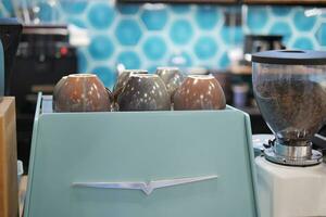 blue color coffee cup lined up on a coffee machine at cafe . photo