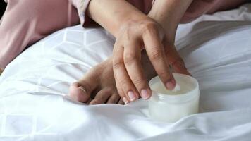 woman applying petroleum jelly on feet on bed video