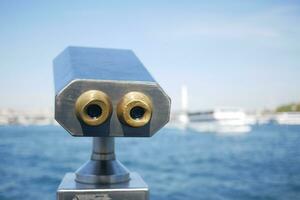 Coin-operated binoculars looking out over city , photo