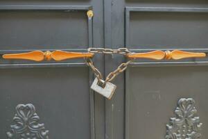 Closed old rusty lock on a wooden door photo