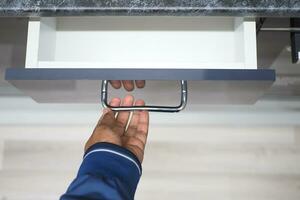 man's hand open drawer wooden in cabinet photo