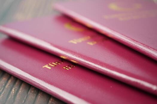 stack of red color passport on table photo