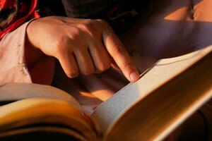 Muslim women's hand reading quran at night photo