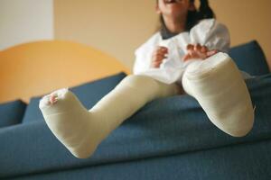 little child with plaster bandage on leg. photo