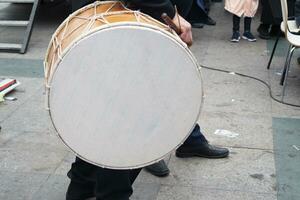 un hombre golpear el antiguo tambor con musical instrumento. foto