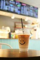 cold coffee in a plastic container with smile shape design on it photo
