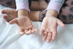 niño espectáculo su mano sentado en cama foto