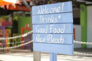 Bienvenido bebidas, bueno comida y bonito playa firmar foto