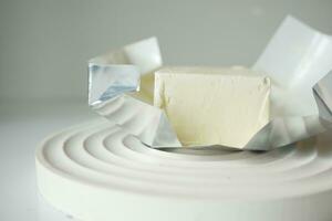 slice of a butter on a paper on table photo