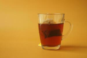 taza de té con té bolso en naranja color antecedentes foto