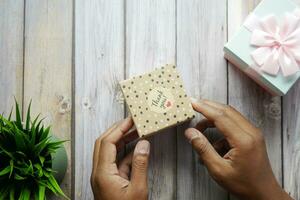 hand putting a thank you sticker on a gift box photo