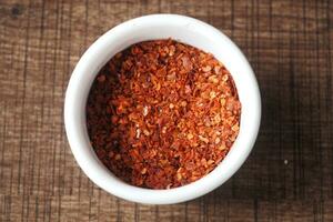 chili flakes in a bowl on table photo