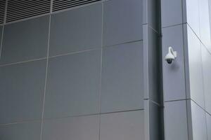 CCTV security camera operating on wall of a building photo