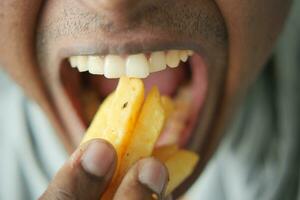 young men eating french fries while sited photo