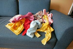 Messy clothes on sofa at home photo