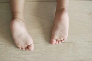 close up of dry child feet on floor photo