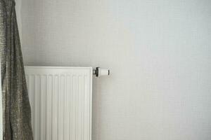White radiator on grey white wall. apartment heating installation system, photo