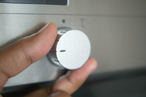 woman hand setting temperature control on oven. photo