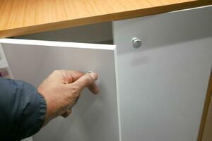 man's hand open drawer wooden in cabinet photo