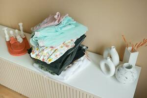 Stack of clothes on table indoor. photo