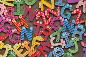 colorful plastic letters on white background, close up photo