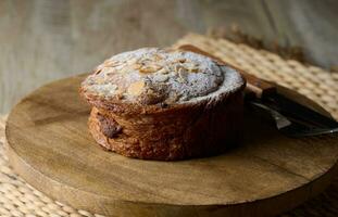 Round pastry with almonds and butter sprinkled with powdered sugar on the table, puff pastry photo