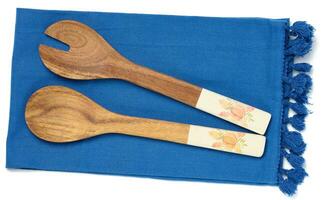 Two wooden spoons on a blue textile kitchen towel, top view photo