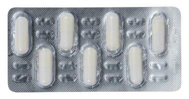 Oval white tablets in blister pack on a white isolated background photo