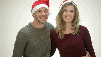 Happy couple in Santa hat laughs while standing in an embrace video
