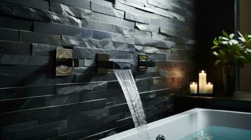 Stylish black marble bathroom and wall-mounted faucet on a stone wall. photo