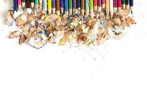 Drawing tools background. Lot of colorful pencils frame with sawdust and shavings on white, copy space, flat lay photo