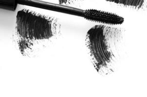 Stroke of black mascara with applicator brush close-up, isolated on white background. - Image photo