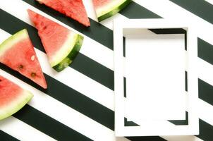 Fresh red watermelon slice on striped background with frame. Summer concept. Top view, Flat lay. - Image photo