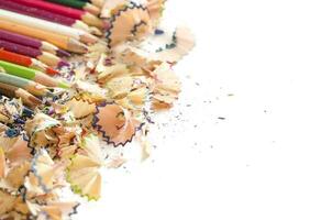 Drawing tools background. Lot of colorful pencils frame with sawdust and shavings on white, copy space, flat lay photo