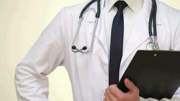 Smiling doctor with clipboard posing on a white background in the studio video