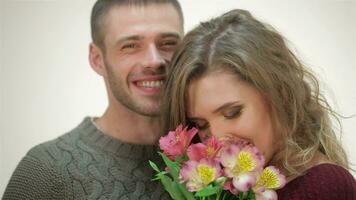Couple in an embrace holding a bouquet of flowers video