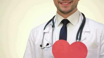 Smiling male doctor with a paper heart video