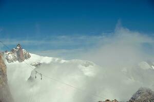 the mountain range of mont blanc covered with snow at punta hellbronner in courmayeur in the aosta valley in july 2023 photo