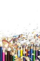 Drawing tools background. Lot of colorful pencils frame with sawdust and shavings on white, copy space, flat lay photo