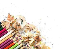 Drawing tools background. Lot of colorful pencils frame with sawdust and shavings on white, copy space, flat lay photo